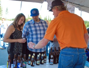 Photo courtesy of Elaine Howell. Gene Diamond from Specialty Imports in Anchorage discusses the beer choices available to Leah Swan and Josh Allison, both of Soldotna.