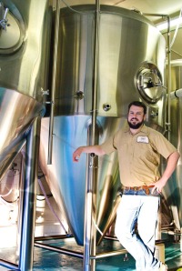 Photo courtesy of Elaine Howell. Devin Wagner, new brewer at Kenai River Brewing Co., stands with the brewery’s new fermenter.